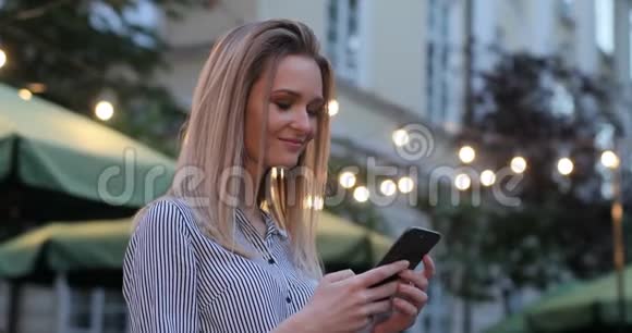 一张漂亮女士在手机上打字的特写照片突然把脸转向相机微笑着视频的预览图