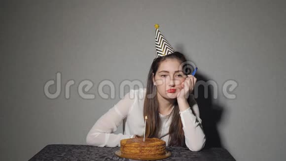 独自悲伤的女孩庆祝节日他独自坐在一张桌子旁桌上放着蛋糕和蜡烛视频的预览图