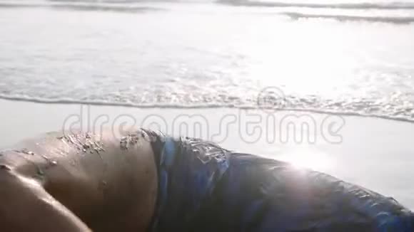年轻的体操运动员在沙滩上翻水视频的预览图