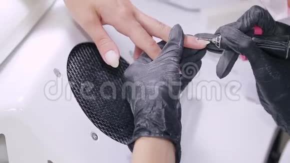 美容店里戴手套的医生处理病人指甲上的角质层视频的预览图