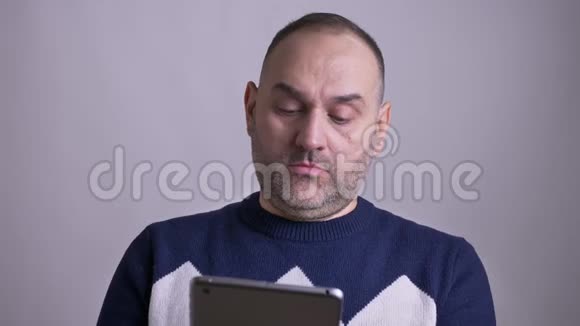 用平板电脑拍摄成年白人男子的特写照片然后看着相机微笑视频的预览图