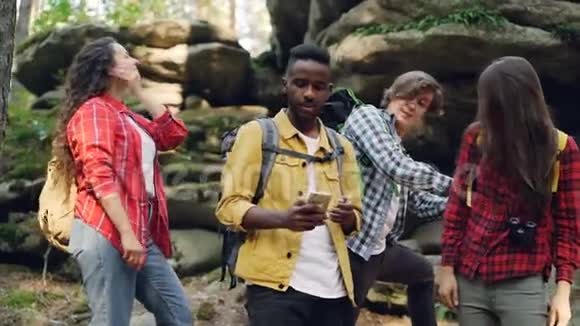 快乐的非裔美国人和朋友在森林徒步旅行时用智能手机打视频电话年轻人视频的预览图