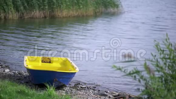 五彩缤纷的小船停泊在湖边的石岸上在夏天阳光明媚的日子里艺术在湖边划船视频的预览图