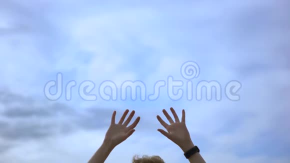 人的双手被高高举起在蓝天的背景下自由的概念艺术戴着手表的人视频的预览图