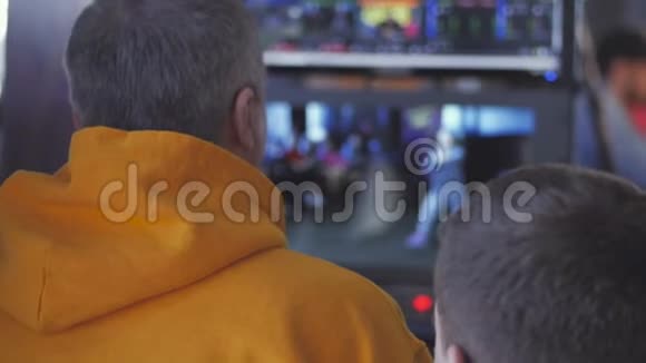 电视项目的导演坐在监视器前擦拭屏幕指导拍摄过程视频的预览图