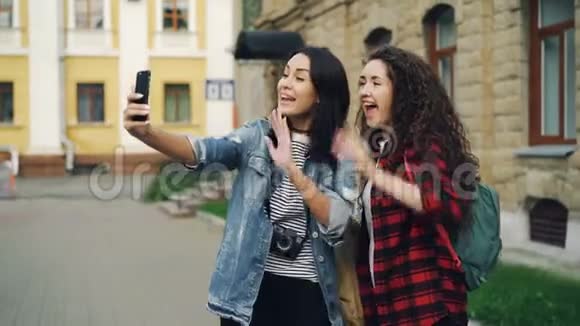 情绪化的年轻女性旅行者使用智能手机手持设备进行在线视频通话和谈话展示视频的预览图