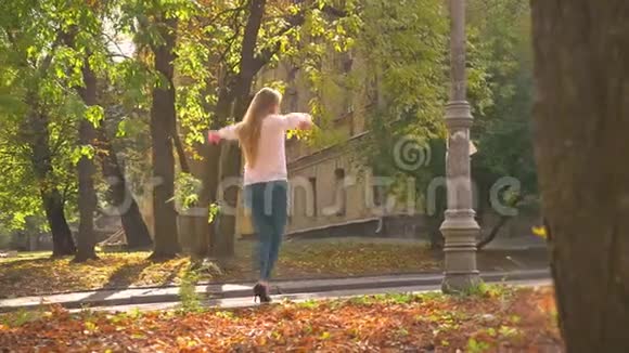 漂亮的白种人金发碧眼的女孩正在公共场所跳舞享受着巨大的阳光视频的预览图