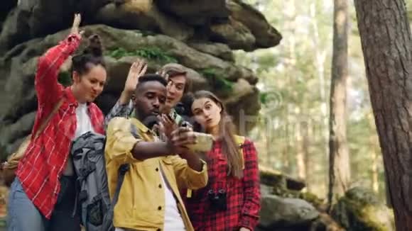 有趣的年轻人快乐的朋友在木头上自拍背景是苔藓岩石非裔美国人是视频的预览图
