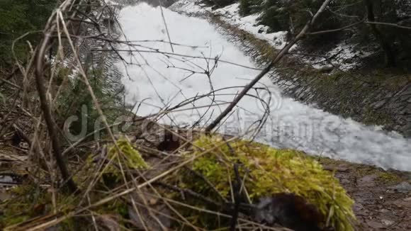 快速流动的瀑布在河流上形成巨大的泡沫位于风景如画的春天早春的自然之地视频的预览图