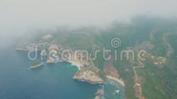 从空中俯瞰蓝色的海洋波浪热带岛屿云层中有山脉视频的预览图