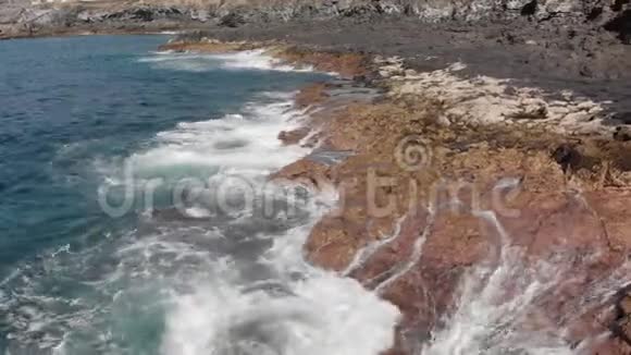 空中射击火山海岸的圆形飞越景观是黄色和棕色的大石头和波浪视频的预览图