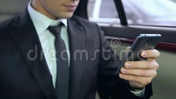 年轻的男老板坐在车里用智能手机商务会议视频的预览图