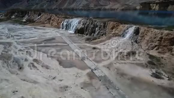 瀑布从蓝色的湖飞到沙漠的河床视频的预览图