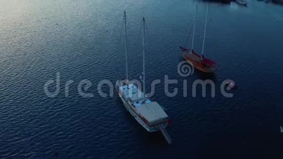 缓慢上升的镜头在游艇在海上显示度假海湾与山与日落空中镜头视频的预览图