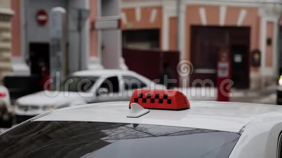 关闭出租车橙色屋顶标志与检查人员背景的汽车视频的预览图