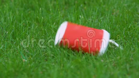 公园草地上的塑料杯乱扔垃圾问题人类对环境的影响视频的预览图