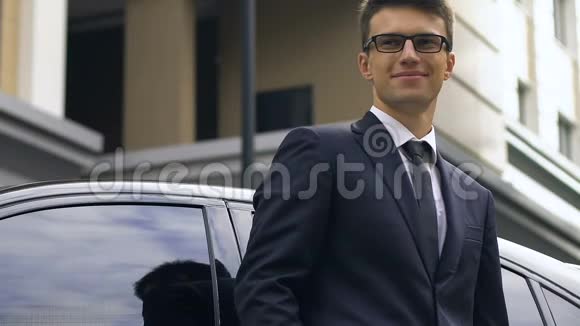 自信的商人站在汽车旁开心地微笑着成功地成交了视频的预览图