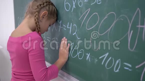 学校教育让站在黑板旁用数学例子的女学生心烦意乱视频的预览图