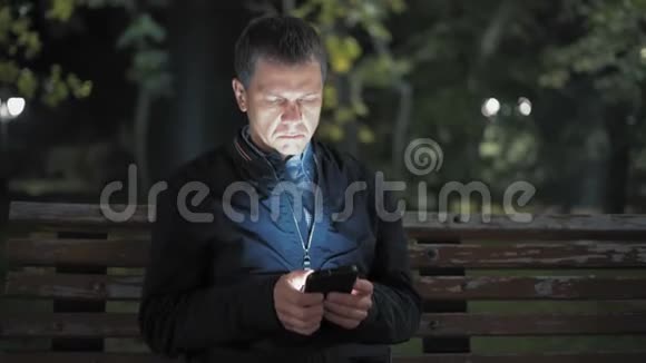 傍晚时分一个孤独的男人在智能手机上给他的女孩写了一条信息视频的预览图