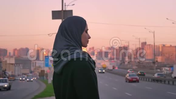 戴着头巾站在路边在镜头前摆姿势的年轻穆斯林女性的特写镜头视频的预览图
