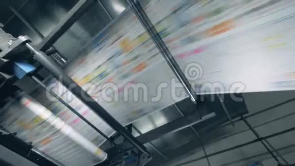 彩色报纸在印刷输送机上滚动自动机器视频的预览图
