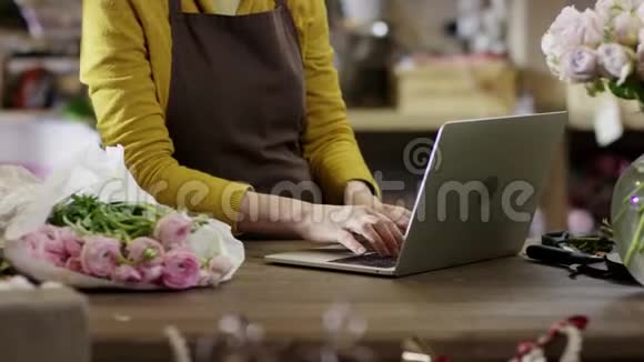 穿黄色上衣的女人在笔记本电脑上印得很快手上印着特写视频的预览图