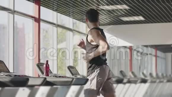 健身中心跑步机锻炼中跑步者男子训练视频的预览图