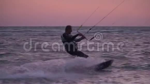 一个人在海上放松在黎明时风筝冲浪慢动作视频的预览图