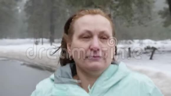 年长的白种人女人冬天在雪地公园跑步关闭前面跟随射击慢动作视频的预览图