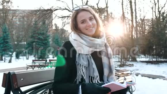 公园里有魅力的年轻女人的肖像在笔记本上做一些笔记视频的预览图