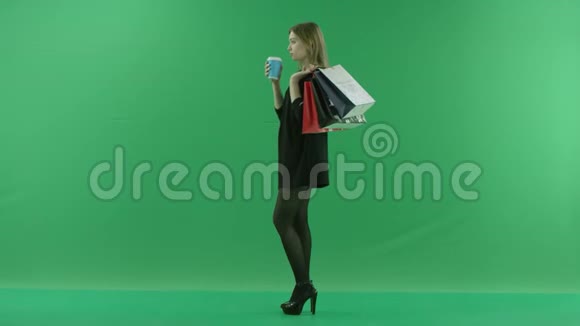 适合年轻女性喝鸡尾酒背后有购物袋颜色关键绿色背景视频的预览图