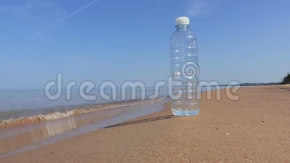 一个人手里拿着一瓶水在海边漫步视频的预览图