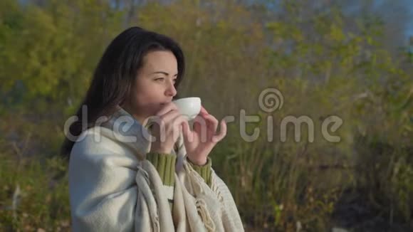 日出时喝茶的美女裹着格子呢视频的预览图