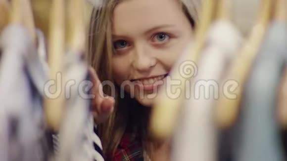 在一家服装店里一位年轻快乐迷人的女士正在寻找新衣服视频的预览图