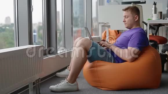 在现代办公室工作的年轻人坐在沙袋上视频的预览图