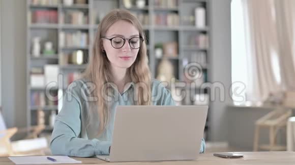 青年妇女在笔记本电脑上进行视频聊天的画像视频的预览图