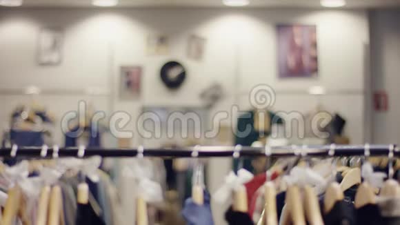 快乐的年轻女子在服装店的货架上寻找新衣服却走开了视频的预览图