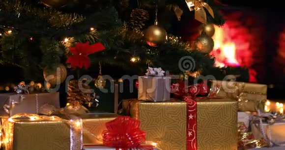 在靠近壁炉的圣诞树下放礼物的女人视频的预览图