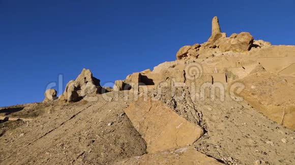 蓝色天空的岩石和沙子上被侵蚀和破坏的古代遗址景观视频的预览图