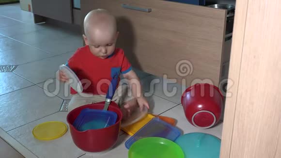 淘气的孩子在厨房地板上玩碗视频的预览图