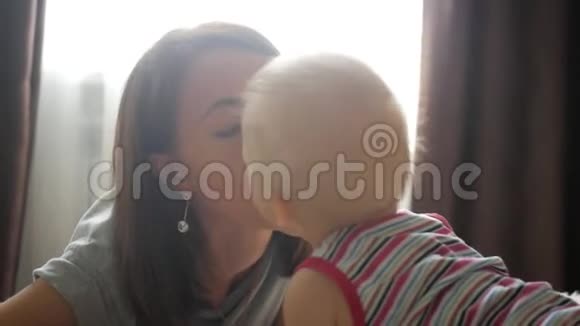 可爱的婴儿亲吻他的母亲年轻的女人和小孩子玩得很开心家庭母亲养育子女人视频的预览图