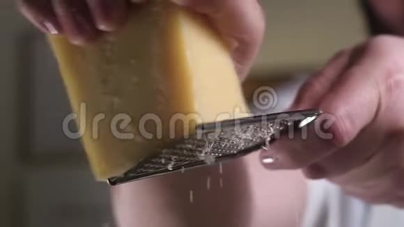 一大块帕尔马干酪被摩擦在一个金属研磨器上快关门慢动作视频的预览图
