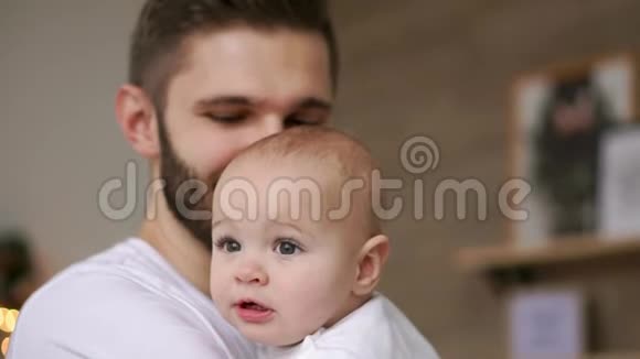 大胡子爸爸亲宝宝紧紧抱着幸福的父亲和孩子宝宝摸着爸爸手上的手表视频的预览图