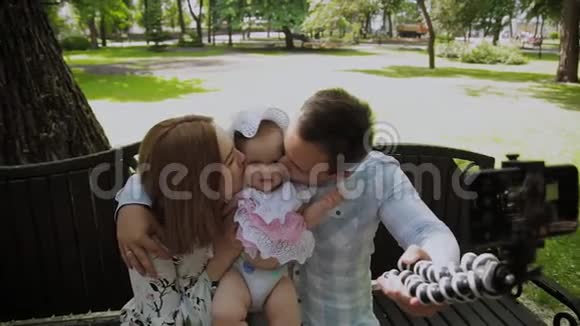 有孩子的幸福家庭在公园的长凳上自拍视频的预览图