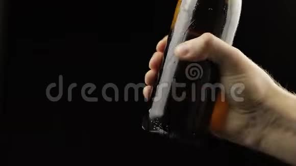 人摇一瓶啤酒啤酒开始倒出泡沫在盖子下面视频的预览图