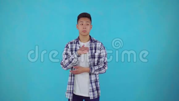 体贴的亚洲青年蓝色背景视频的预览图