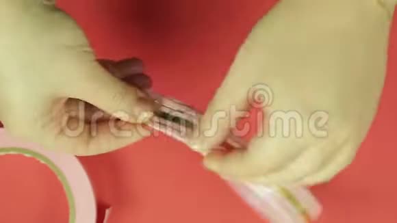 女人们的手在空白的粉红缎带上剪了一个角做礼物鞠躬红色背景视频的预览图