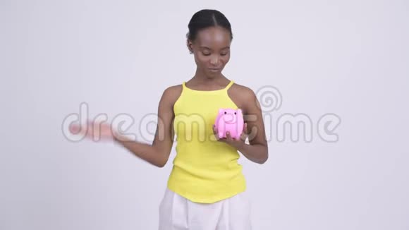 快乐的年轻非洲女人手里拿着储蓄罐竖起大拇指视频的预览图