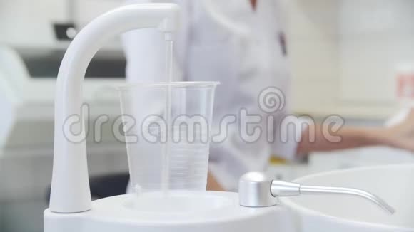在牙医办公室在塑料杯里的自来水流动背景有个牙医视频的预览图