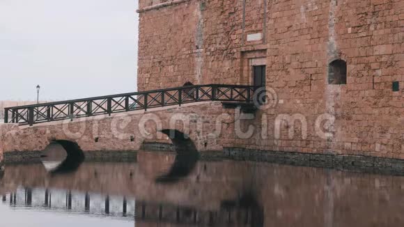 帕福斯城的历史城堡砖堡部分侧视木制城堡桥展示在水中入口美景视频的预览图